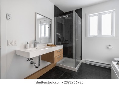 white bathroom counter with wood-colored drawer with a corner glass shower and a window