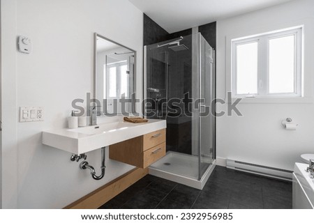 white bathroom counter with wood-colored drawer with a corner glass shower and a window