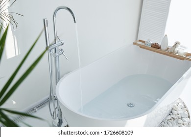 White bathroom modern interior. Luxurious decor with plants, window, spa at home. Bathtub is filled with tap water, nobody - Shutterstock ID 1726608109