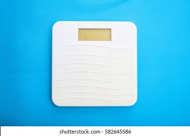 White Bathroom Scale On A Blue Background