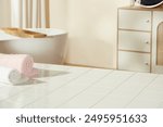 A white bathroom table with blank space for product displaying, decorated with some colorful bath towels. Photo was taken from high angle with copy space for adding text