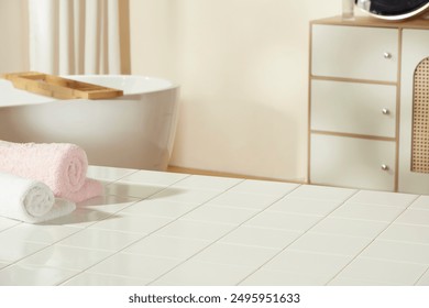 A white bathroom table with blank space for product displaying, decorated with some colorful bath towels. Photo was taken from high angle with copy space for adding text