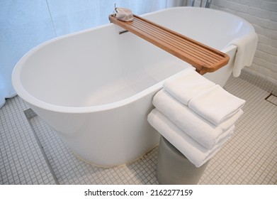 White Bathroom With Towels And Bathtub