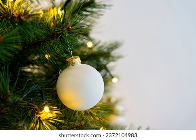 White bauble hanging on chistmas tree