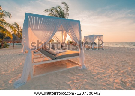 White beach canopies at sunset. Luxury beach tents at luxurious beach resort. Summer beach concept, relaxation and tranquility design. Serenity view, carefree, rest seaside, idyllic landscape and sky