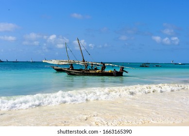 White beach and deep blue sea with fisherboats at the West coast of Sansibar