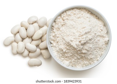 White bean gluten free flour in a white ceramic bowl next to a pile of white beans isolated on white. Top view.
