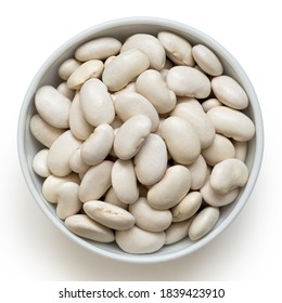 White beans in a white ceramic bowl isolated on white. Top view.