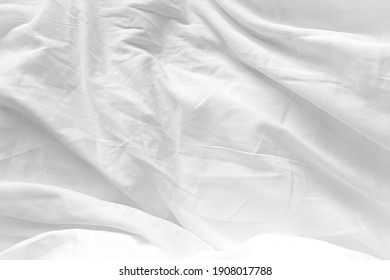 White Bedding Sheet Texture Close-up. Cotton Sheet Creased Drapery Fold Structure On Bed. Unmade Textile Background Wrinkle Blanket.