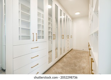 white bedroom with cushions make up table walk in closet and large windows