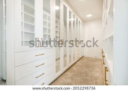 white bedroom with cushions make up table walk in closet and large windows