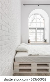 White Bedroom With Double Bed, Brick Wall And Half Circle Window