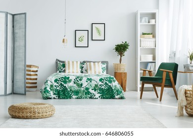 White bedroom with screen, bed, armchair, bookcase, lamp and pouf - Shutterstock ID 646806055