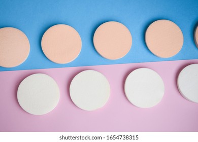 White and beige makeup sponges on the blue and pink background, Close up, Cosmetic sponges powder for face makeup, Cosmetic sponges, Beauty concept