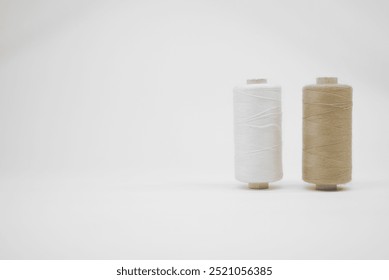 White and beige thread spools on a white background - Powered by Shutterstock