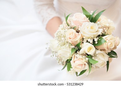 White, beige wedding bouquet. Bride, hands, arms