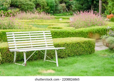 A White Bench In An English Garden.