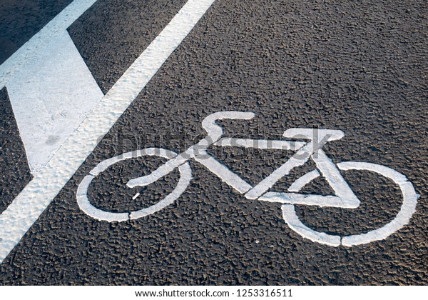White bicycle sign on\
asphalt bike lane