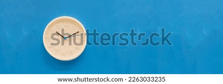 White big analogue plain wall clock on trendy pastel blue background. copy space, time management concept and opening or closing hours.time management and business concept