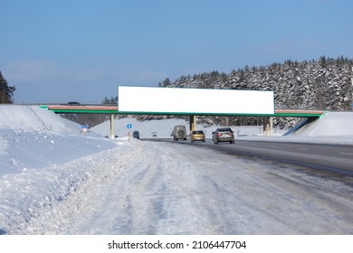 White Billboard Along The Highway On A Winter Snow Day. Background For Design And Advertising. 