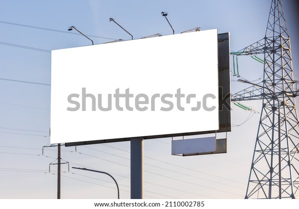 white billboard along the\
highway on a winter snow day. Background for design and\
advertising. 