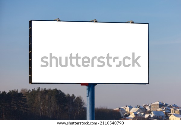 white billboard along the\
highway on a winter snow day. Background for design and\
advertising. 