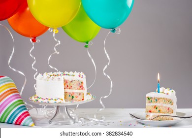 White birthday cake with colorful balloons