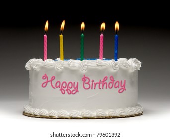 White birthday cake profile gradient background and five colorful lit candles   