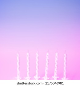 White birthday candles ready for party purple   pink background  Minimal birthday party concept and copy space for wishes  Ready for cake  Gradient colored and light effect background 