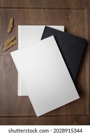 White And Black Books Lying On The Dark Wooden Table. Mockup Book Cover On The Table. Blank Empty Book Or Notebook Cover. 