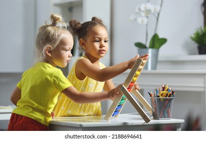 White and Black children sit together at the table and count on the abacus and smiles. Math lesson in elementary school - Powered by Shutterstock