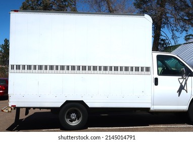 White And Black Piano Moving Truck. Black And White Keys Decorate The Exterior.