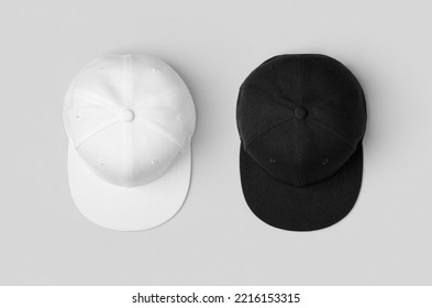 White and black snapback caps mockup, side by side.