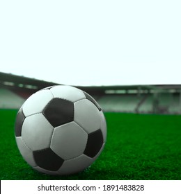 White And Black Soccer Ball On Green Grass And Stadium Background. Sports Betting Idea