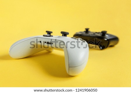 White and black two joystick gamepad, game console on yellow colourful trendy modern fashion pin-up background. Computer gaming competition videogame control confrontation concept. Cyberspace symbol