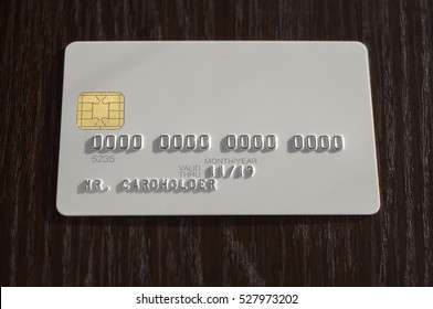 White blank bank credit card on dark wooden background