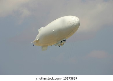 White Blank Blimp Against A Blue Sky.