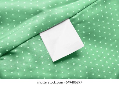 White Blank Clothes Label On Green Silk As A Background