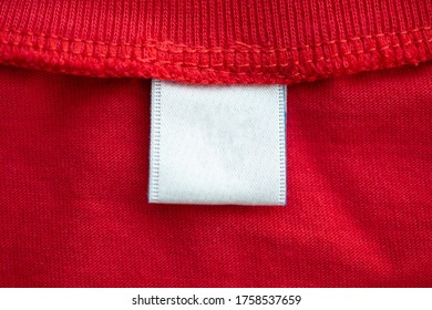 White Blank Clothing Tag Label On New Red Cotton Shirt Fabric Texture Background