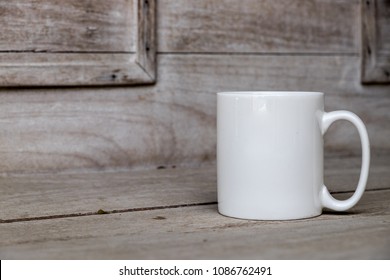 White blank coffee mug mock up against a wooden background. Perfect for businesses selling mugs, just overlay your quote or design on to the image.