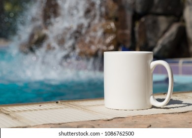 White blank coffee mug mock up, set on the poolside with a waterfall in the background.	Perfect for businesses selling mugs, just overlay your quote or design on to the image.