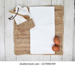 White Blank Cotton Kitchen  Tea Towel Mockup For Design Presentation With  Wooden Spoon, Cutting Board And Eggs.