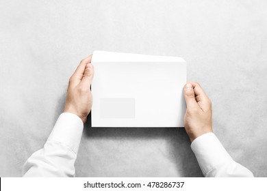 White blank envelope mock up holding in hand. Empty letter with transparent window design mockup. Message template presentation. Person opening clear mail.