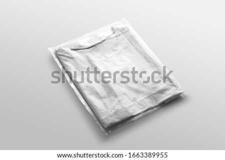 White blank folded tshirt mockup to place your design in transparent plastic bag, on white background fashion branding scene