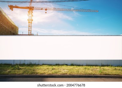 White blank hoarding poster with mockup space on construction site under blue sky - Shutterstock ID 2004776678