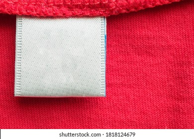 White Blank Laundry Care Clothes Label On Red Cotton Shirt Background