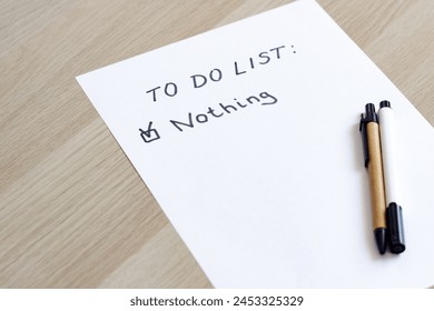 A white blank note or sheet of paper is on a wooden table background. To do list concept with no plans. 