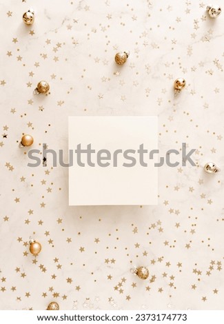 White blank paper square card mockup and golden various sizes stars confetti on white Christmas background. Minimal Christmas or New year aesthetic template. Flat lay, top view