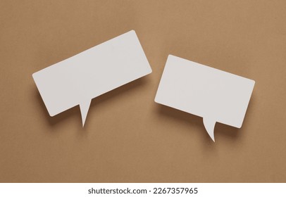 White blank paper-cut speech bubble on brown background. Chat, social media, discussion. Mock up for template design