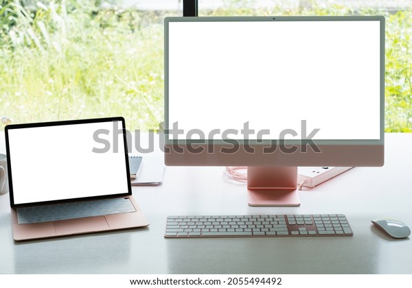 White blank screen monitor and laptop on modern\
working desk.